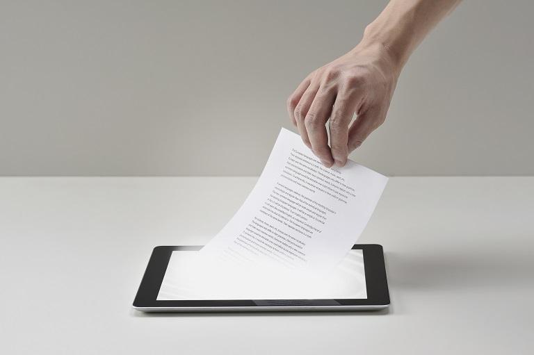 Ręka wyciągająca dokument z czytnika e-booków